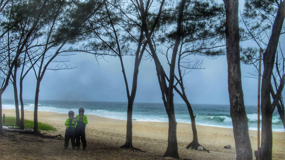 Vista da Praia do Recreio dos Bandeirantes no Rio de Janeiro em um dia chuvoso, com foco na beleza da paisagem e no ambiente natural.