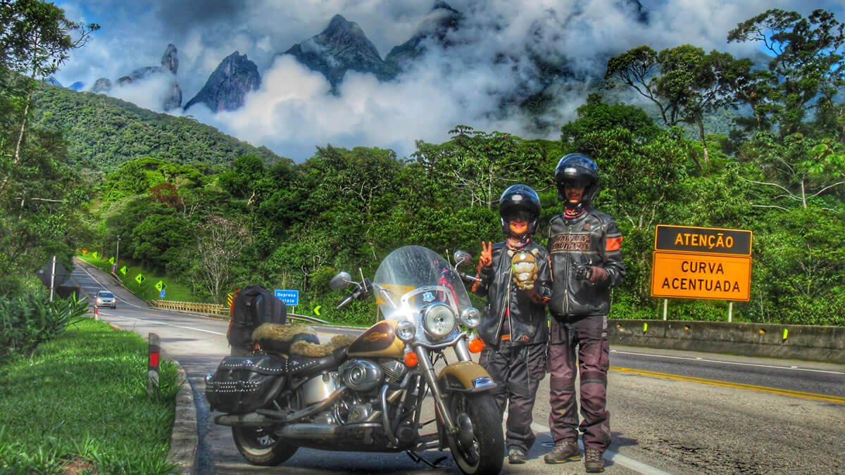 Imagem da rodovia BR-116 com a imponente Serra dos Órgãos ao fundo, capturando a beleza da paisagem em uma viagem pelo Rio de Janeiro.