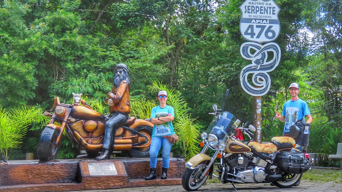 Motociclistas ao lado de uma Harley-Davidson no Monumento do Rastro da Serpente, famosa estrada com 1.250 curvas entre Paraná e São Paulo.