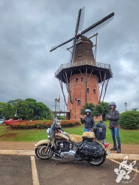 Casal ao lado de uma Harley-Davidson Heritage Softail Classic 2014 estacionada em frente ao Moinho Povos Unidos, um dos principais cartões-postais de Holambra, São Paulo, Brasil. Foto: FredLee Na Estrada.