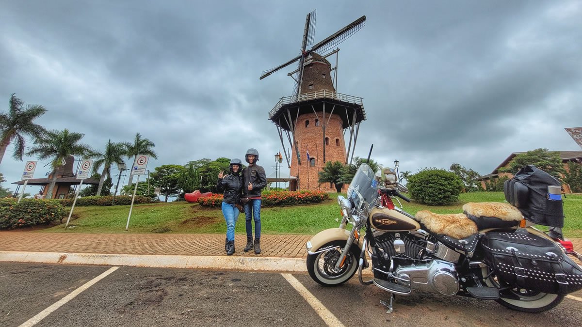 Moinho Povos Unidos em Holambra (SP), com casal e motocicleta Harley-Davidson em frente ao cartão-postal da Cidade das Flores